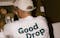 A worker packaging wine wearing the Good Drop merch t-shirt with the green good drop logo