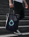 Person carrying the Hydroflow tote bag with water drop logo in blue designed by 4AM